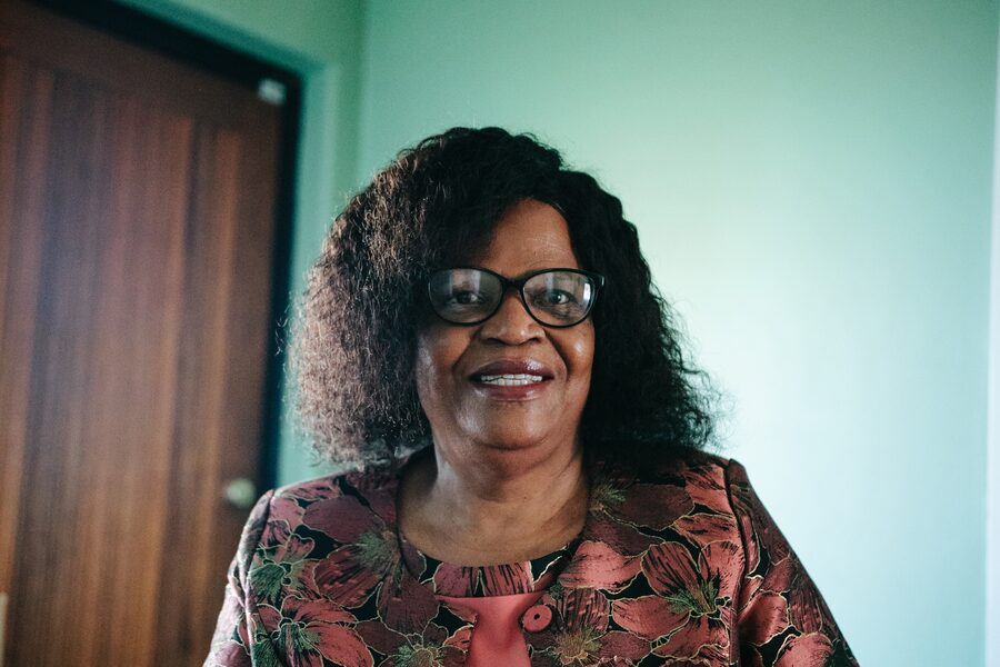 Coach Thato in conversation at her table, an open book in front of her